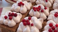 there are many desserts with white frosting on top of each other and pomegranates