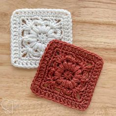 two crocheted squares sitting on top of a wooden table