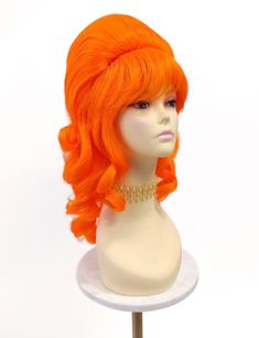 Retro beehive costume wig. Caged-style hollow interior cap with adjustable elastic straps, no combs or clips. Non heat-resistant.  Color: Neon Orange Length: 17" inches Circumference: Default at 21" with adjustable cap (max 22"). Materials: Synthetic Wig Fiber ★ All sales are final. Please read all store policies before purchasing. ★ Faster shipping options available at checkout.  ★ Please check our shop announcements for shop updates and bulk order discounts! ★ Follow Us! Instagram, TikTok, Pinterest, Facebook Beehive Costume, 60s Costume, Costume Wigs, Synthetic Wig, Neon Orange, Bee Hive, Vintage 60s, Synthetic Wigs, Bright Orange