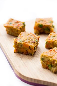 several pieces of food sitting on top of a wooden cutting board