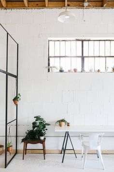 a white table and some plants in a room