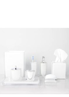 the bathroom accessories are neatly arranged on the counter in front of the white wall,