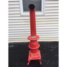 a red fire hydrant sitting in front of a window on the side of a house