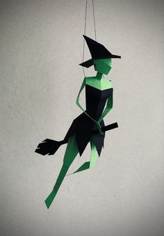 an origami witch hanging from a string