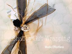 a black ribbon tied to a piece of wood with flowers on it and the words shabby gift wrapping made effort