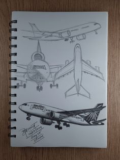 two drawings of airplanes on a wooden surface