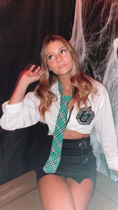 a young woman wearing a green tie sitting down