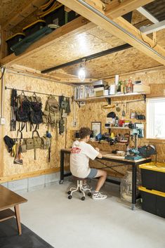 a man sitting at a workbench in a garage