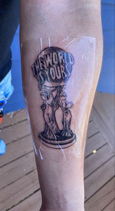 a person with a tattoo on their leg that says, the world is your cup