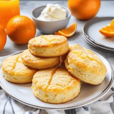 biscuits and oranges on a table with cream