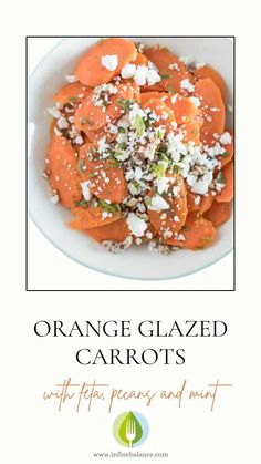 an orange glazed carrots with feta cheese and mint in a white bowl on a table