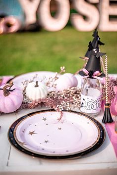 a table set with plates, napkins and decorations for a halloween themed dinner party