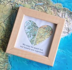 a wooden frame with a map and two hearts in it