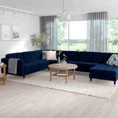 a living room with blue couches and white rugs on the wooden flooring