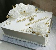 a white cake with gold decorations and flowers on it