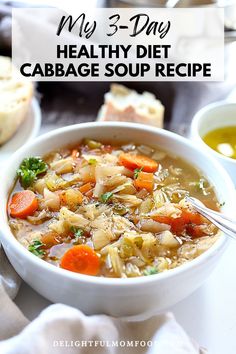 a bowl of cabbage soup with carrots and broccoli in it, next to bread