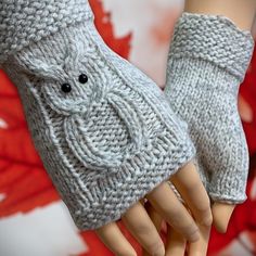 a pair of gray knitted gloves on top of a mannequin's hand