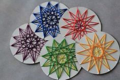 four circular coasters with colored paper stars on the top one is white and the other is multicolored