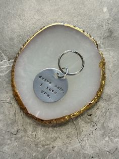 a piece of glass with a metal keychain that says, give me i love you