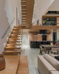 a living room filled with furniture next to a staircase