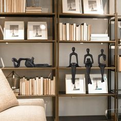 a living room filled with lots of bookshelves covered in figurines next to a couch