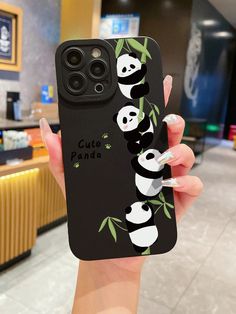 a woman holding up a phone case with pandas on it