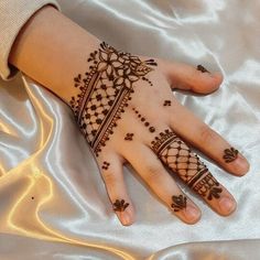 a woman's hand with henna tattoos on it