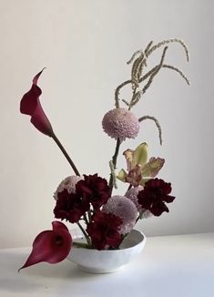 a white vase filled with flowers on top of a table