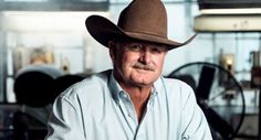 an older man wearing a cowboy hat sitting at a desk