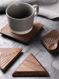 wooden coasters with geometric designs and a cup of coffee on the table next to them