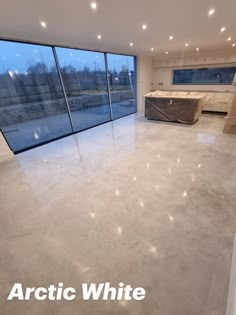 an empty room with large windows and white marble flooring in front of glass walls