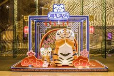 an animal display in front of a wall with chinese writing on it and decorations around it