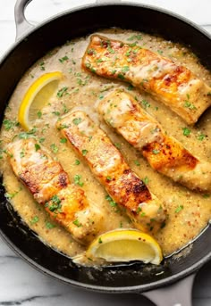 chicken with lemon sauce in a skillet on a marble countertop, ready to be eaten