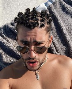 a shirtless man laying on top of a towel