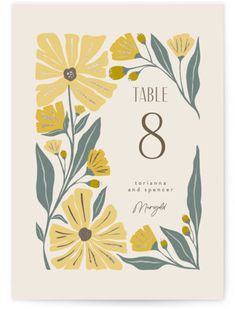 a table number card with yellow flowers and green leaves on the front, white background