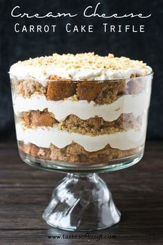 a cake with white frosting and crumbs on top sitting in a glass dish