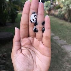 a person holding up their hand with two panda bears painted on it's fingers