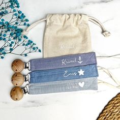 three personalized wooden spoons sitting on top of a white marble counter next to a drawstring bag