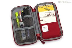 an open travel case with pens, markers and pencils in it on a white background