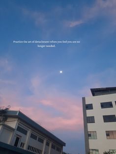 the sky is pink and blue with some clouds in it, while buildings are white