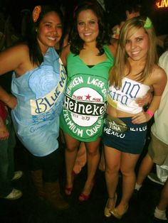 three beautiful young women standing next to each other in front of a group of people