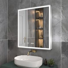 a bathroom sink sitting under a mirror in front of a wall mounted cabinet with lights