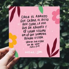 a person holding up a card with the words in spanish on it and flowers all over them