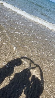 the shadow of a person riding a bike on the beach