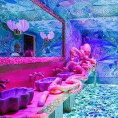 the colorful bathroom is decorated with pink and purple decor, including octopus like decorations on the walls