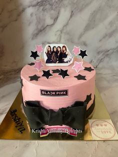 a pink cake with black stars on it