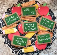 decorated cookies with teacher's chalkboards and pencils are on a doily