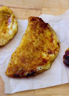 two pieces of pizza sitting on top of wax paper