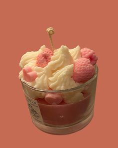 a cup filled with lots of white and pink frosted food on top of a table