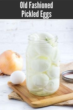 a jar filled with onions sitting on top of a wooden cutting board next to an onion slice